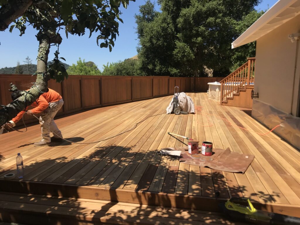 A cleared backyard space with landscape fabric and gravel ready for deck construction.